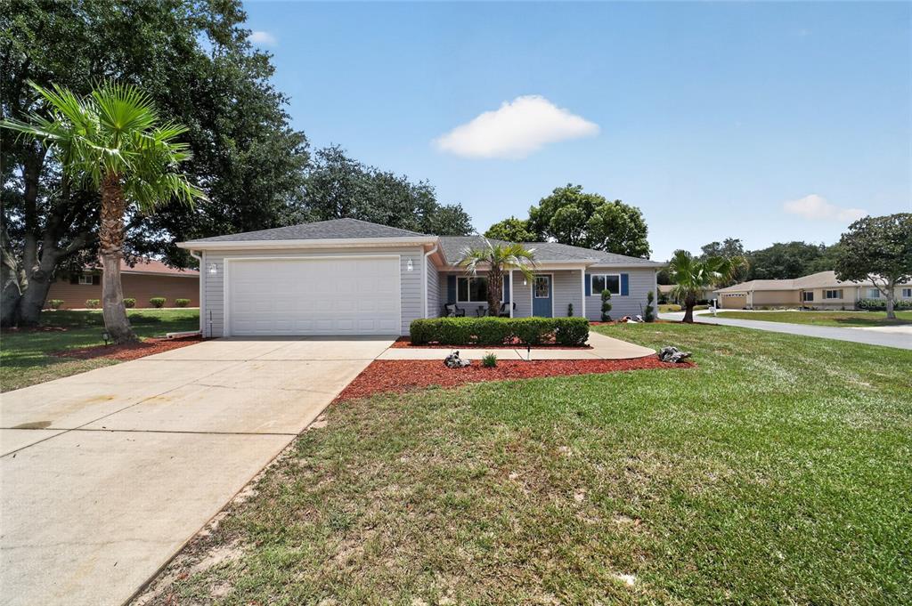 A single-story house with gray siding, a two-car garage, and a front lawn — 13685 SE 90TH COURT, SUMMERFIELD, FL