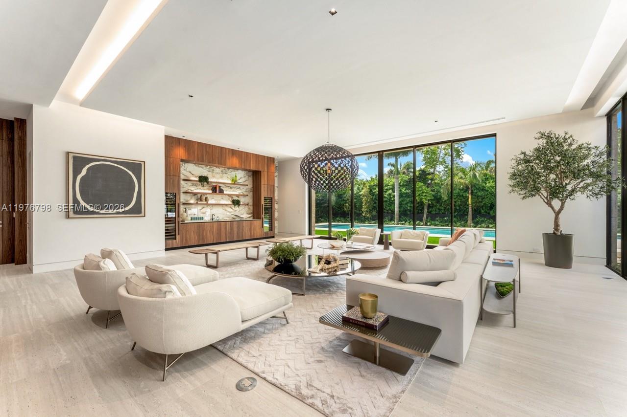 A modern living room features a large sectional sofa, a bar area, and floor-to-ceiling windows — 8755 SW 54th Ave, Miami FL 33143, MIAMI, FL