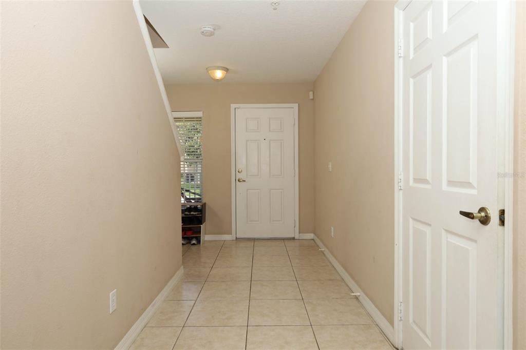 An entryway features beige walls, light-colored tile flooring, a white front door, and a staircase — 188 STERLING SPRINGS LANE, ALTAMONTE SPRINGS, FL