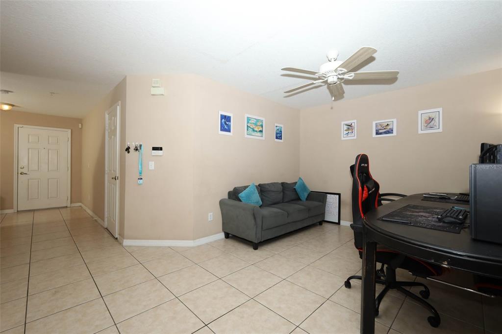 A living room features tile flooring, a gray sofa, and a desk with a gaming chair — 188 STERLING SPRINGS LANE, ALTAMONTE SPRINGS, FL