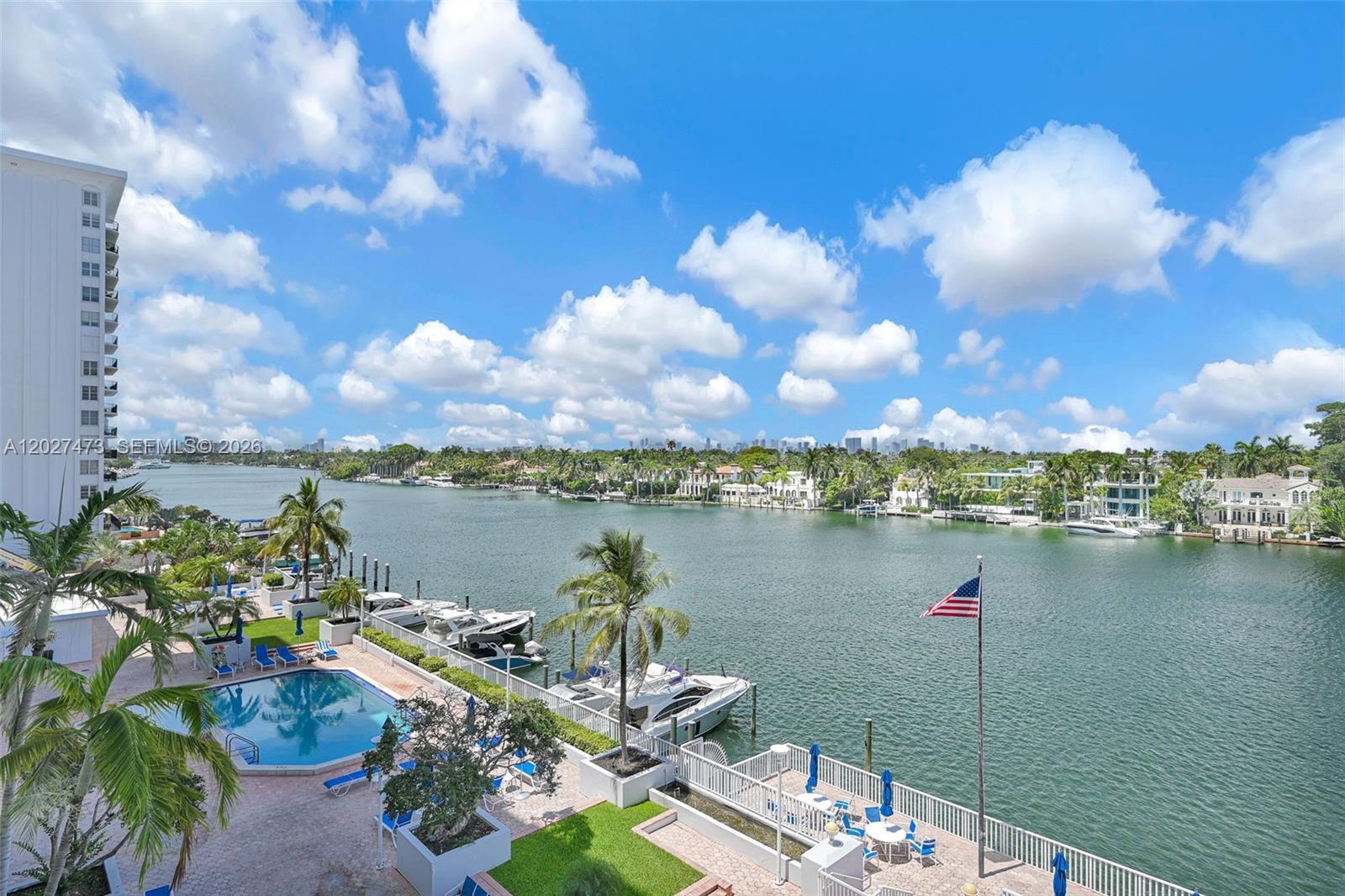 An elevated view of a waterfront pool deck with boats docked along a canal — 5700 Collins Ave # 5J, Miami Beach FL 33140, MIAMI BEACH, FL