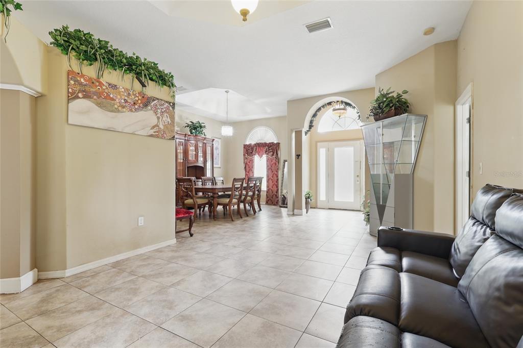 A spacious room with tile flooring, a dining set, and a leather sofa — 4510 BRAZILNUT AVENUE, SARASOTA, FL