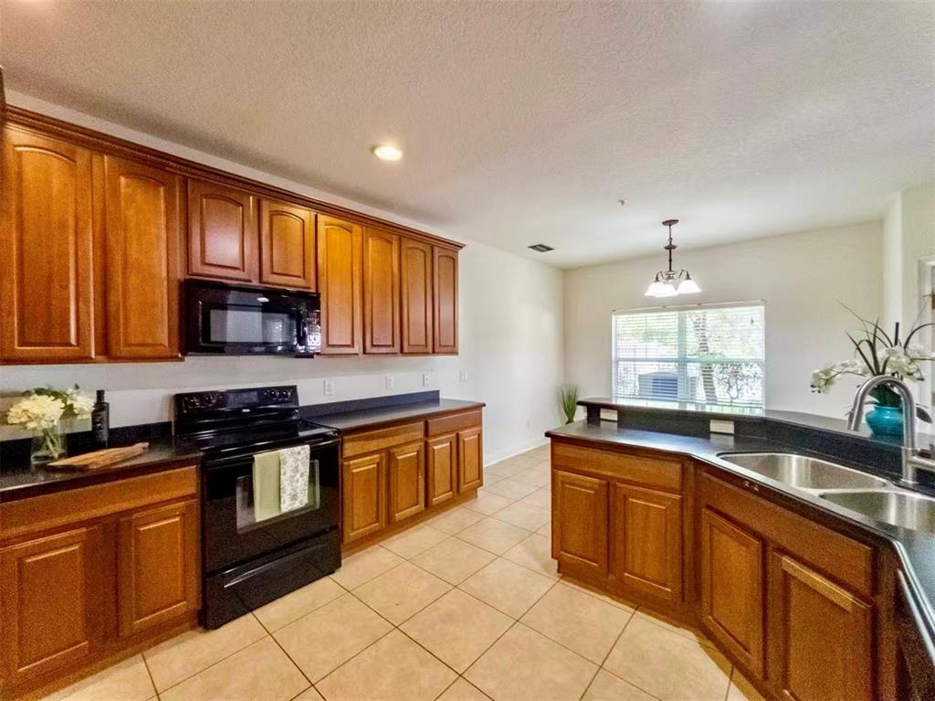 This virtually staged living room features a fireplace, neutral furniture, and a ceiling fan — 7174 REGINA WAY, ORLANDO, FL