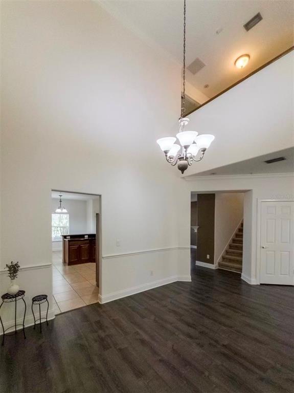 A dining room features a large arched mirror, a wooden table, and light gray chairs — 7174 REGINA WAY, ORLANDO, FL