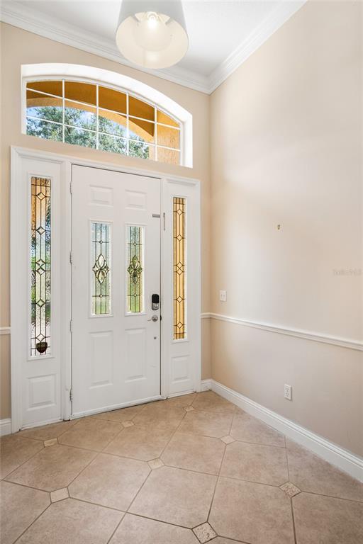 An entryway features a white front door with glass panels, tile flooring, and a transom window — 10734 WOODCHASE CIRCLE, ORLANDO, FL
