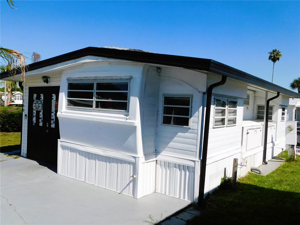 A white mobile home with a black door and trim sits on a concrete pad — 9000 US HIGHWAY 192 UNIT 166, CLERMONT, FL