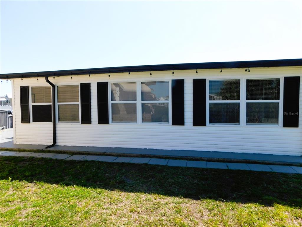 The exterior of a white mobile home features black shutters and a string of lights — 9000 US HIGHWAY 192 UNIT 166, CLERMONT, FL