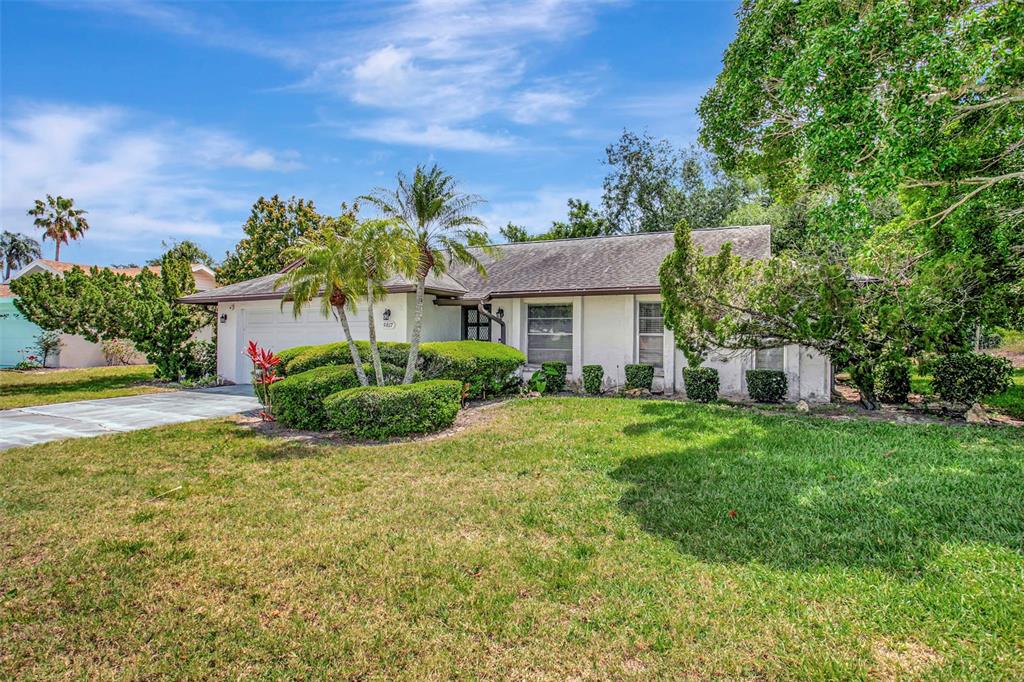 A single-story house with a white exterior, a two-car garage, and a landscaped front yard — 5817 11TH AVENUE W, BRADENTON, FL