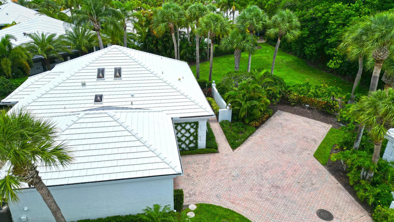 An aerial view shows a house with a white tiled roof and a paved driveway — 4501 Captains Way, Jupiter FL 33477, JUPITER, FL