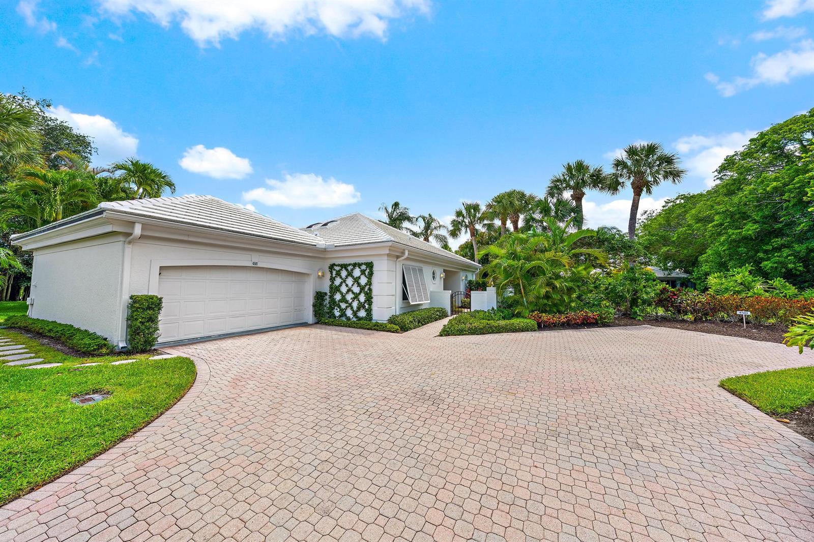 A single-story house with a white exterior, tiled roof, and a paved circular driveway — 4501 Captains Way, Jupiter FL 33477, JUPITER, FL