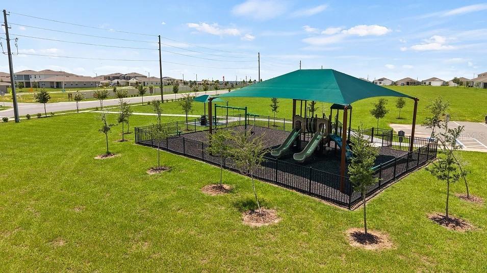 An aerial view of a fenced playground with a green shade canopy and slides — 2707 GINGER LANE, HAINES CITY, FL