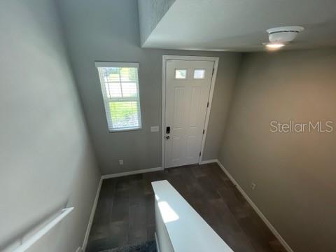 A high-angle view of an entryway with gray walls, a white door, and tiled flooring — 3314 FRESNO PL, ZEPHYRHILLS, FL