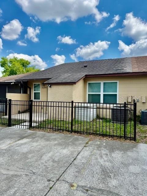 A single-story house exterior features a black metal fence, a concrete driveway, and two windows — 1254 SOPHIE BOULEVARD, ORLANDO, FL