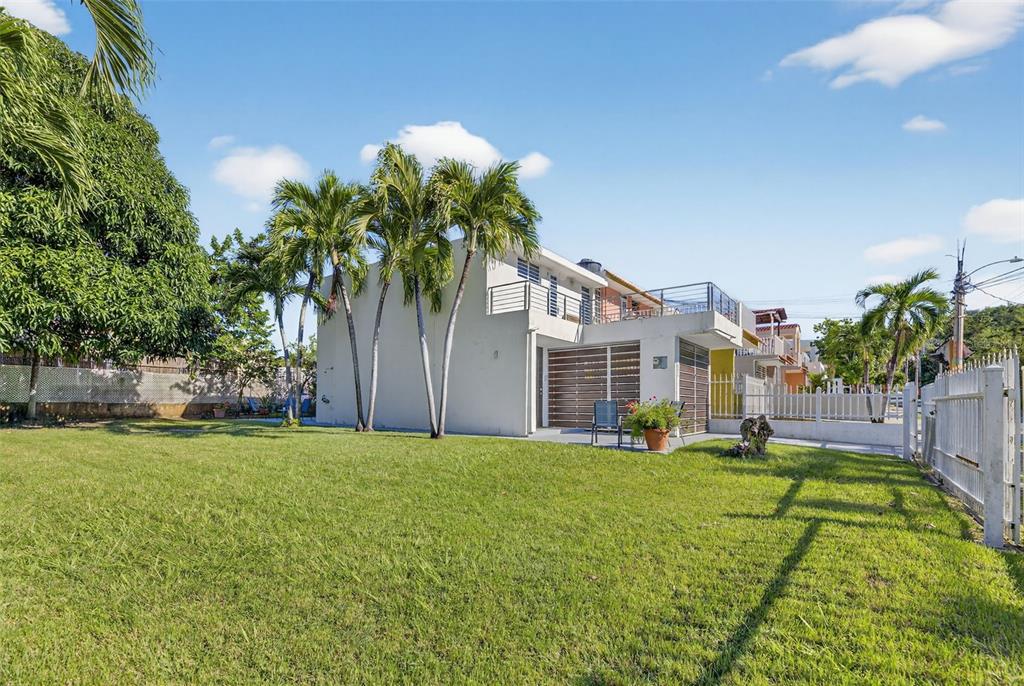 A two-story house with a large grassy yard, palm trees, and a second-floor balcony — D-1-20 CALLE CAMBIJA, RINCON, PR