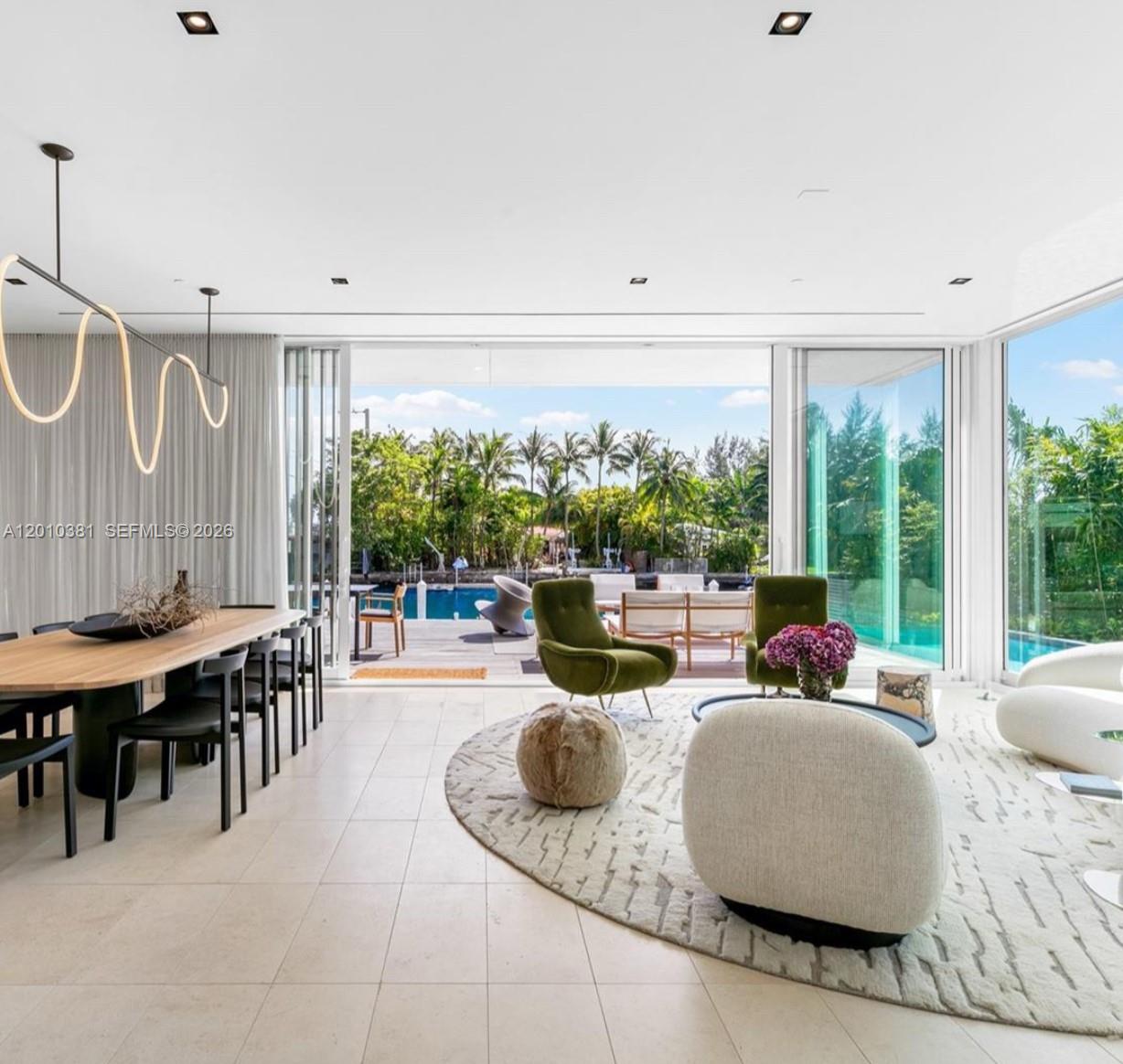 A modern living and dining area opens to a patio with a swimming pool — 1081 W 48th St # N01, Miami Beach FL 33140, MIAMI BEACH, FL