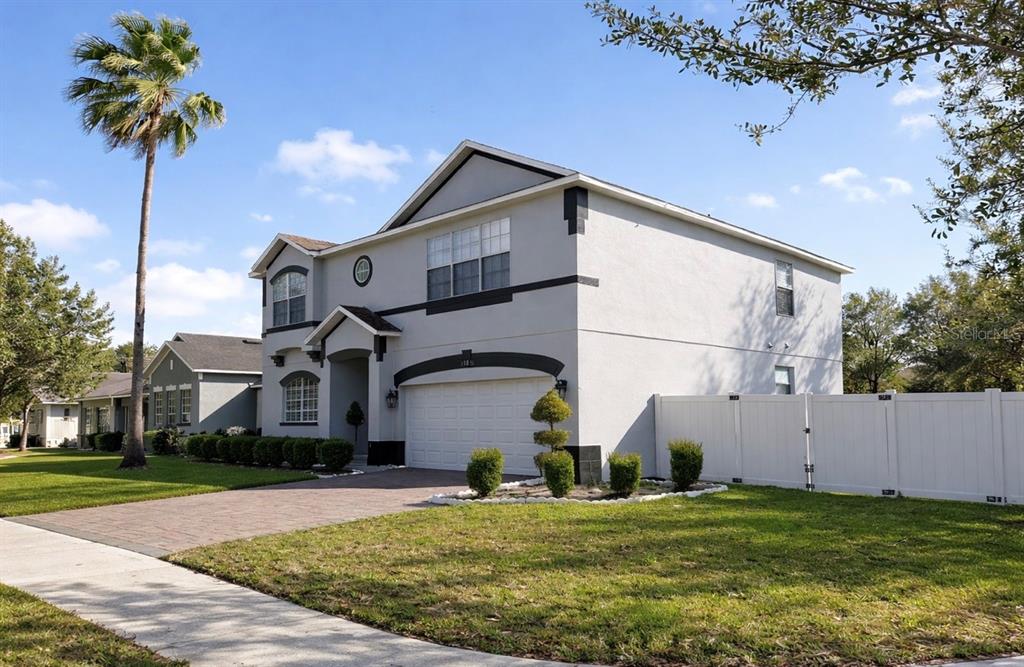 A two-story house with a white garage, gray stucco exterior, and a white privacy fence — 13851 AMBERLEIGH ROAD, ORLANDO, FL