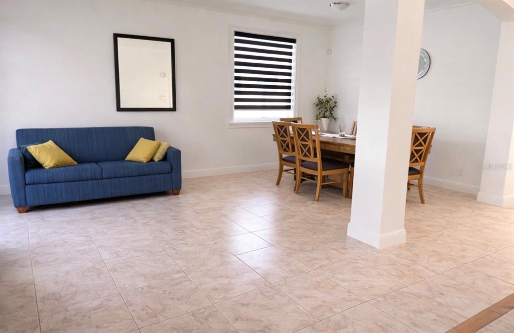 A living and dining area features a blue sofa, a wooden dining set, and tiled floors — 13851 AMBERLEIGH ROAD, ORLANDO, FL