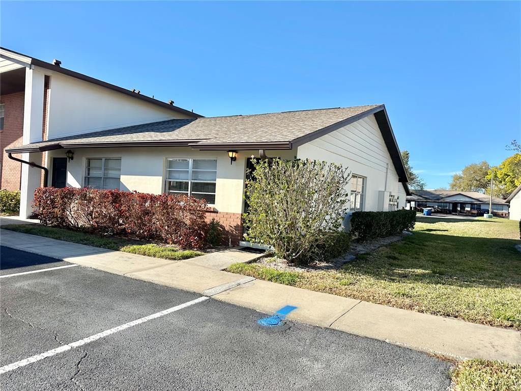 A single-story residential building with white siding, a shingled roof, and a small front yard — 2476 ENTERPRISE ROAD UNIT 6, CLEARWATER, FL