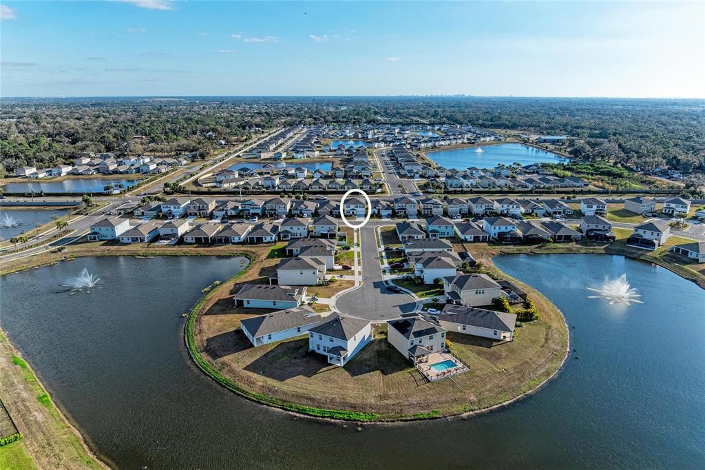An aerial view shows a suburban neighborhood with houses surrounding a cul-de-sac and ponds — 3804 TURNING TIDES TERRACE, BRADENTON, FL