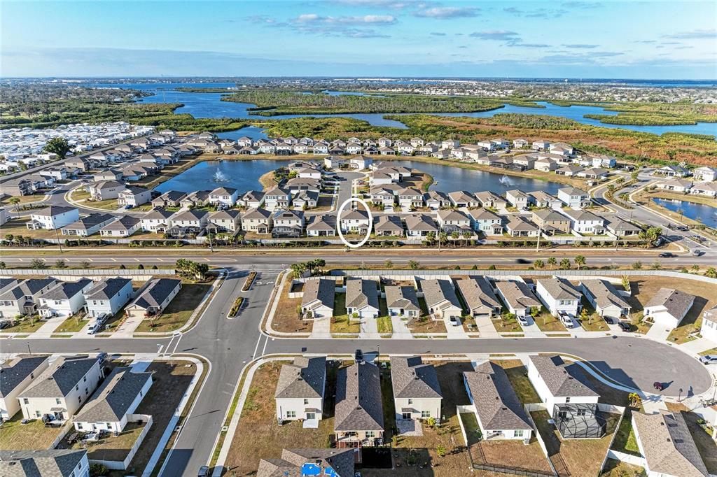 An aerial view shows a residential neighborhood with a circled house near a lake — 3804 TURNING TIDES TERRACE, BRADENTON, FL