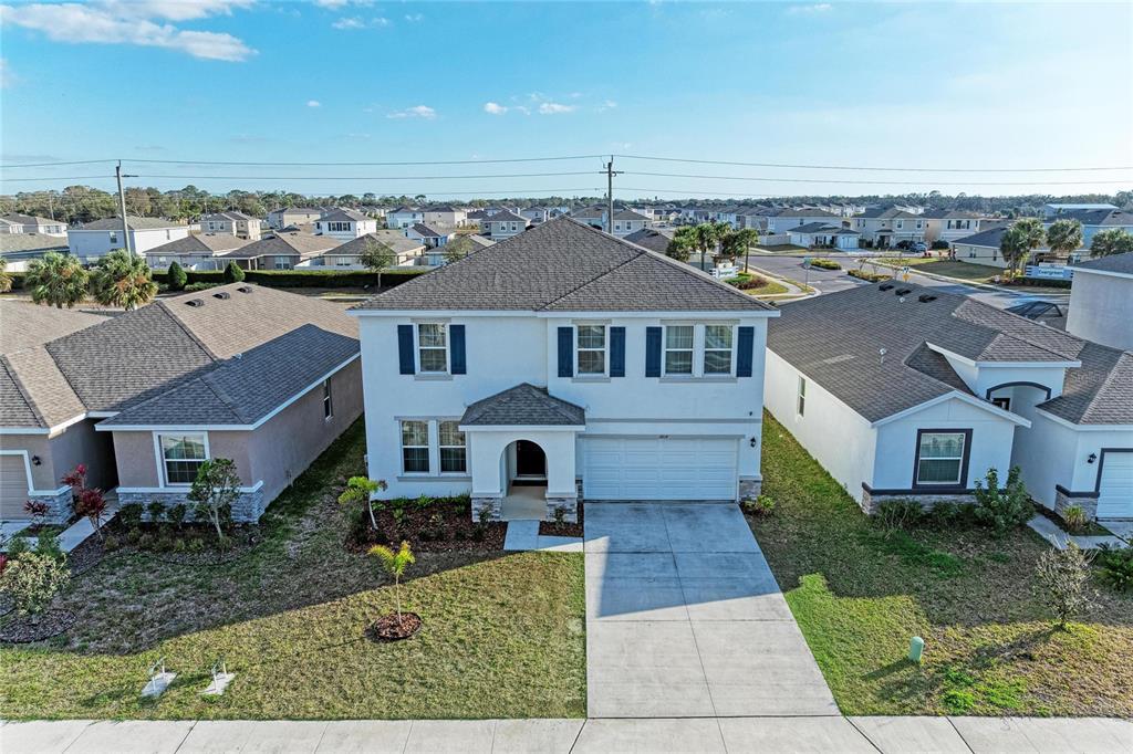 An aerial view of a two-story suburban house with a white exterior and gray roof — 3804 TURNING TIDES TERRACE, BRADENTON, FL