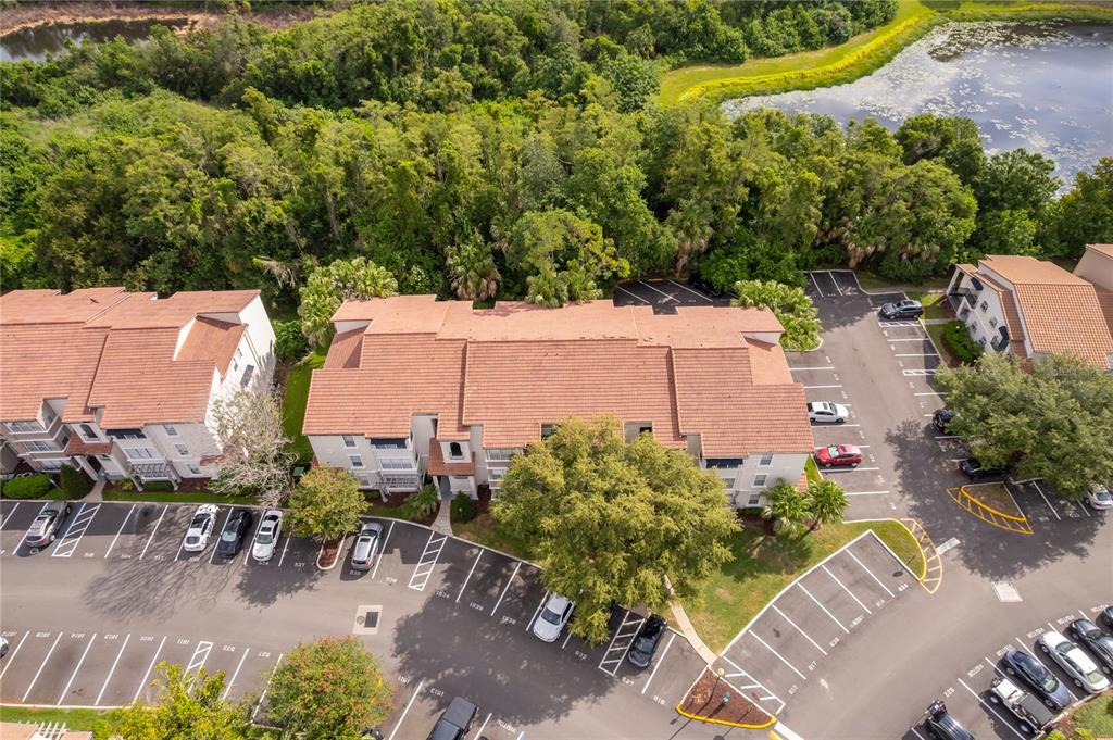 An aerial view shows a multi-story apartment building surrounded by parking lots and dense trees — 5124 CONROY ROAD UNIT 26, ORLANDO, FL