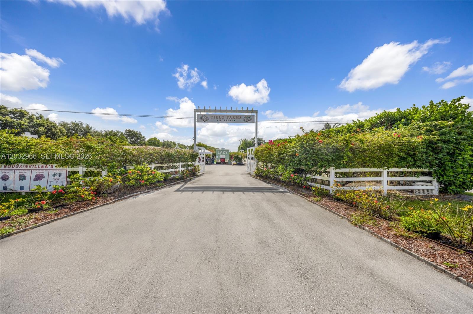 A paved driveway leads to the gated entrance of a nursery with white fencing — 4680 SW 148th Ave, Southwest Ranches FL 33330, SOUTHWEST RANCHES, FL