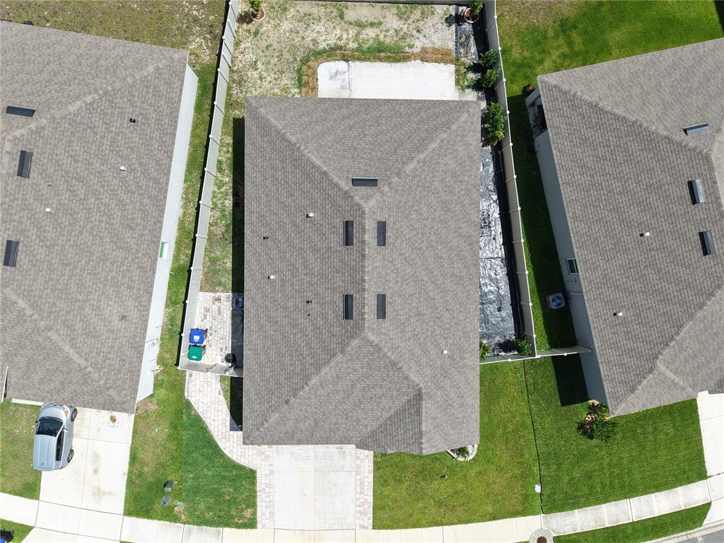An aerial view shows the roof of a house situated between two neighboring homes — 11370 AMBER RIDGE DRIVE, ZELLWOOD, FL