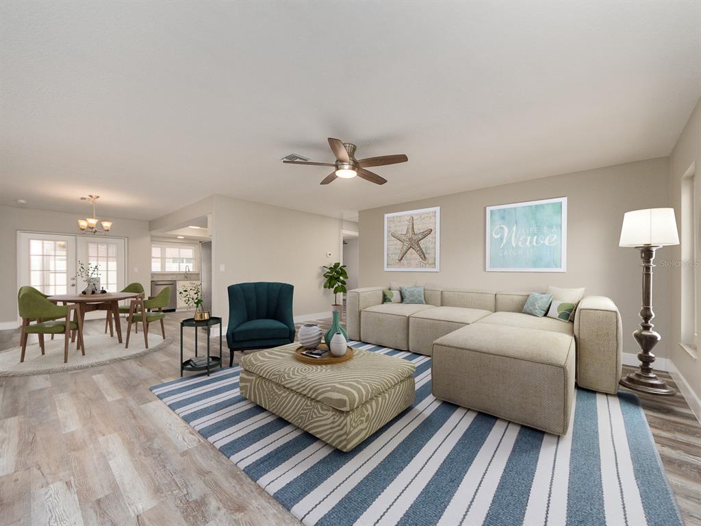 This is a digitally staged living and dining area with a sectional sofa and area rug — 11883 108TH AVENUE, LARGO, FL