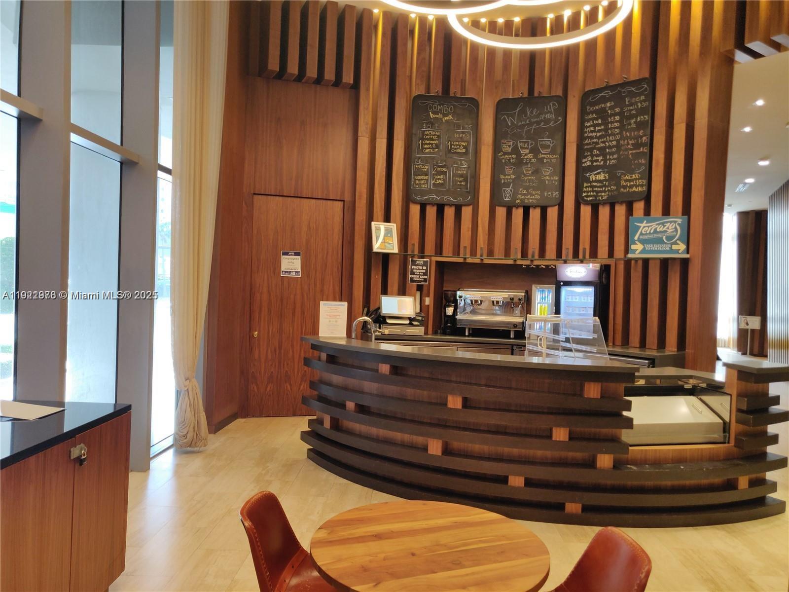 A coffee bar with a curved wooden counter and menu boards on a slatted wall — 4111 S Ocean Dr # 1506, Hollywood FL 33019, HOLLYWOOD, FL