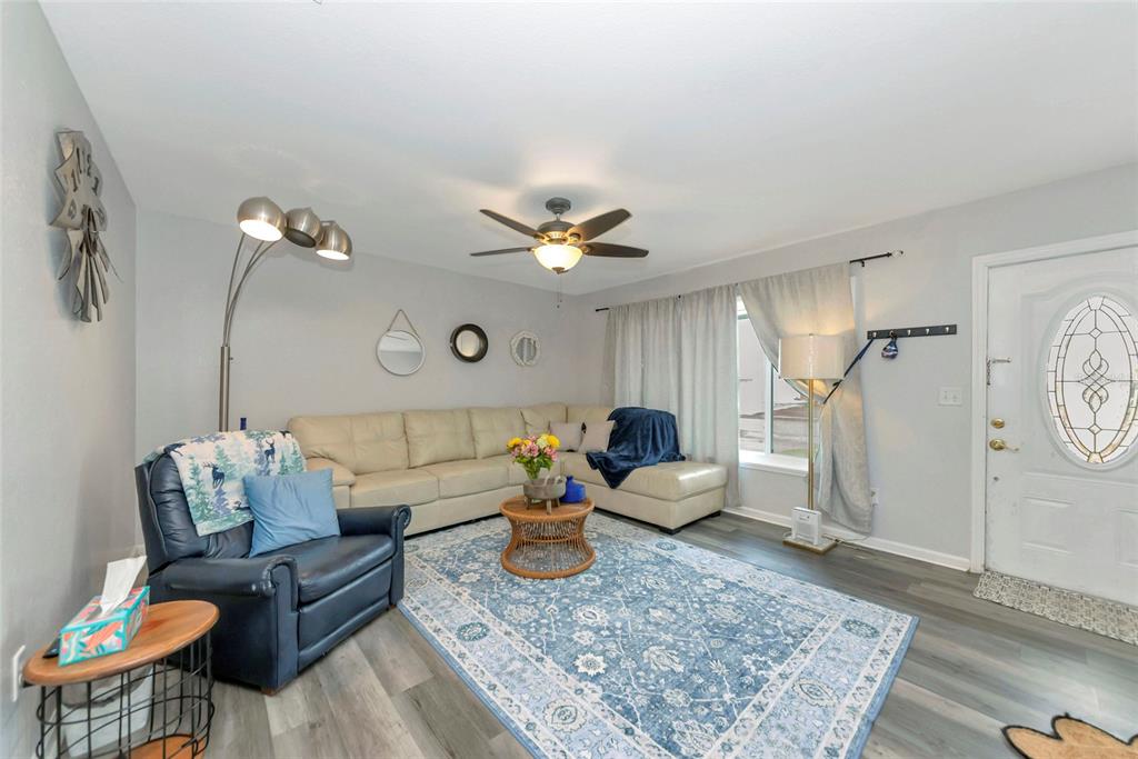 A living room features a sectional sofa, a blue armchair, and a patterned area rug — 6703 ELECTRA AVENUE, NORTH PORT, FL