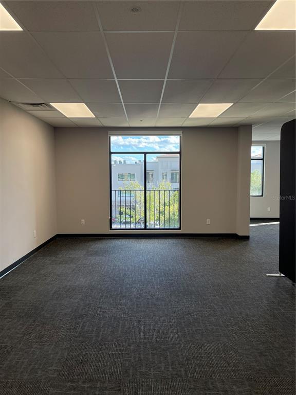 An empty office space features gray carpet, a drop ceiling, and a window with a balcony — 13550 VILLAGE PARK DRIVE UNIT 345, ORLANDO, FL