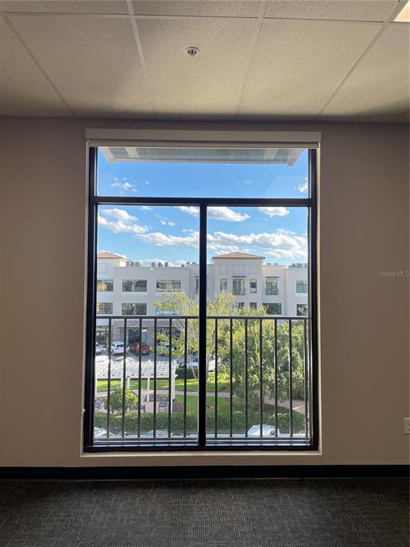 A view of a building exterior through a large window in a carpeted office room — 13550 VILLAGE PARK DRIVE UNIT 345, ORLANDO, FL