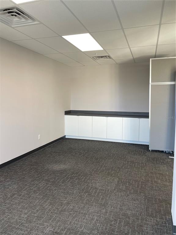 An office space features gray carpet, white cabinets with a dark countertop, and drop ceilings — 13550 VILLAGE PARK DRIVE UNIT 345, ORLANDO, FL