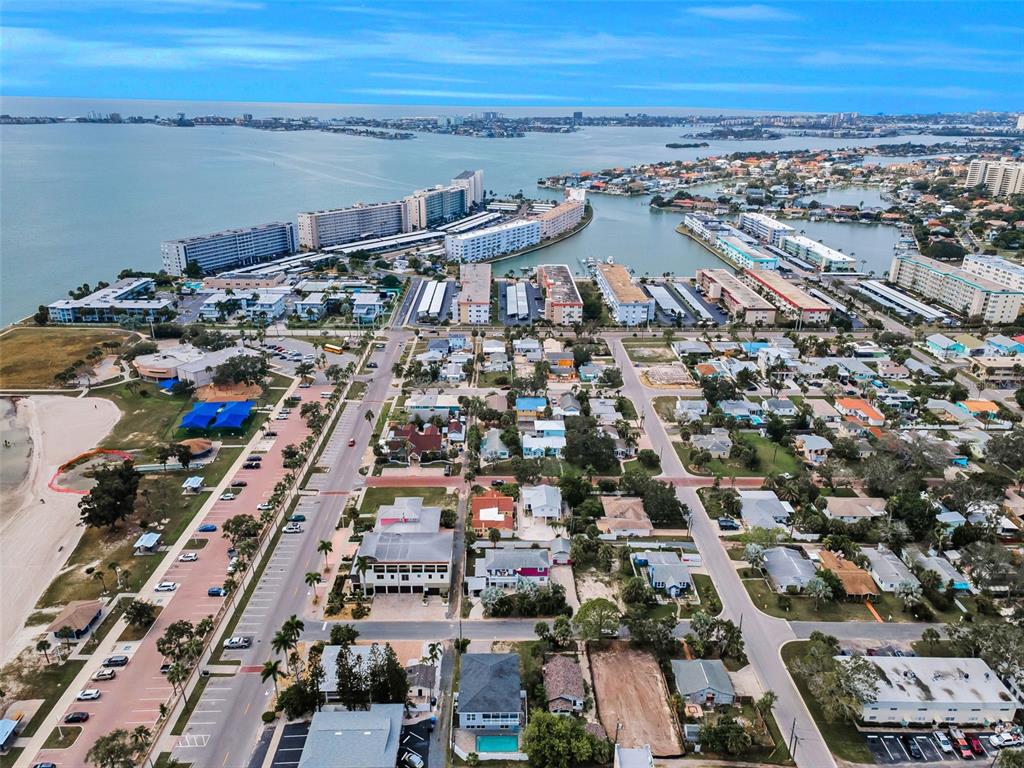 An aerial view shows a coastal neighborhood with residential homes, apartment complexes, and a beach — 3120 CLINTON STREET S, GULFPORT, FL