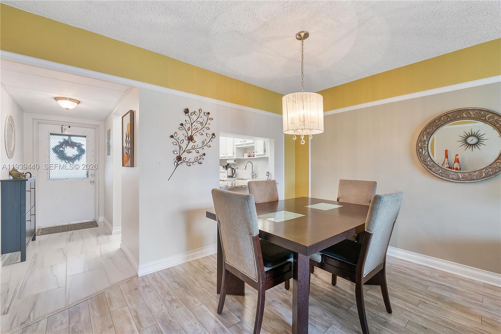 A dining area features a dark wood table, four upholstered chairs, and a drum chandelier — 7847 Golf Circle Dr # 309, Margate FL 33063, MARGATE, FL