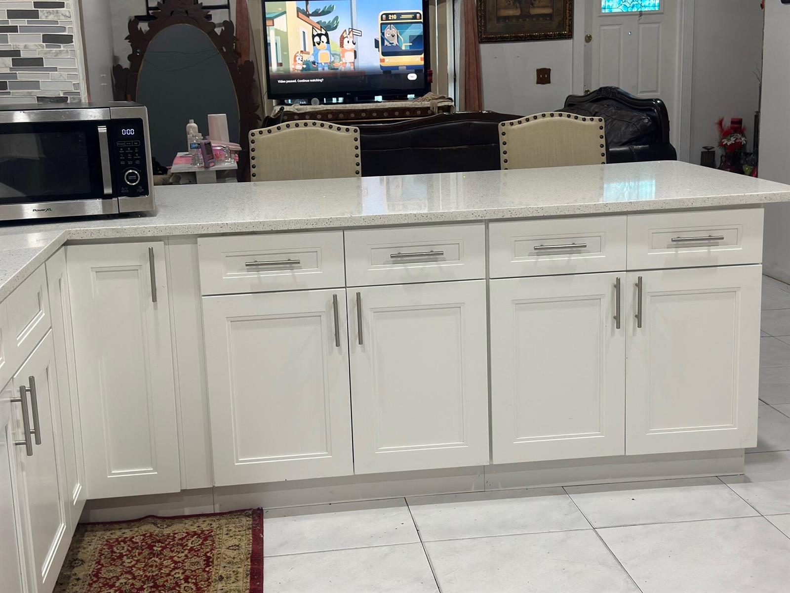 A kitchen island with white cabinets and a light-colored quartz countertop — 5654 E Ithaca Cir Circle E, Lake Worth FL 33463, LAKE WORTH, FL