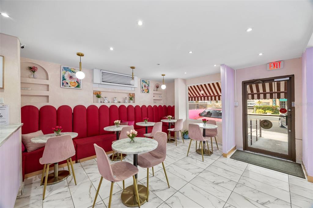 A small cafe interior features a red banquette, marble-topped tables, pink chairs, and tile flooring — 156 WINSTON CHURCHILL AVENUE, SAN JUAN, PR
