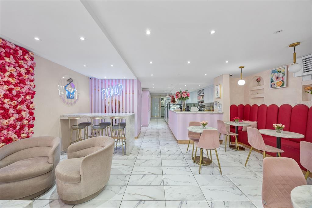 A bright cafe interior features pink floral walls, marble floors, and a pink-themed seating area — 156 WINSTON CHURCHILL AVENUE, SAN JUAN, PR