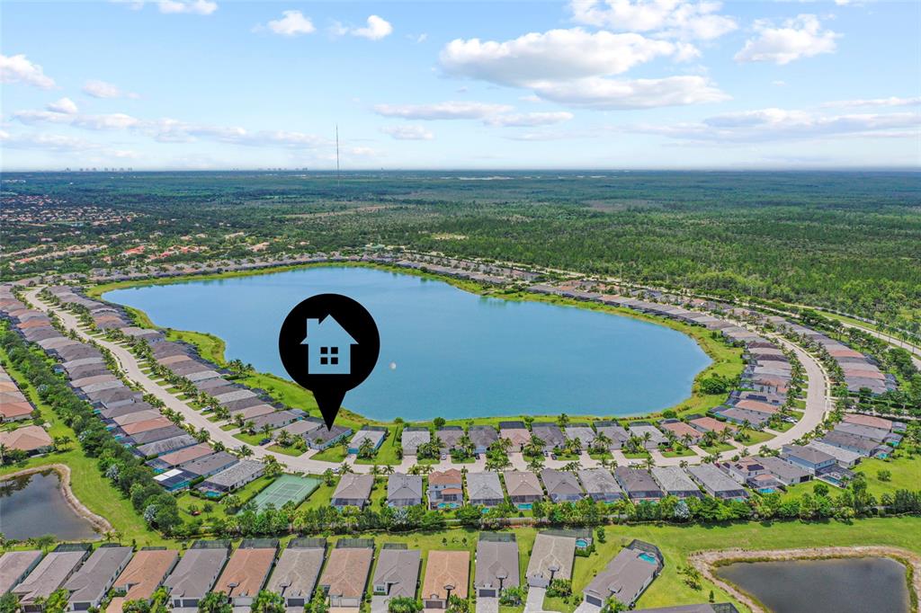 An aerial view shows a residential neighborhood surrounding a large lake — 16279 BONITA LANDING CIRCLE, BONITA SPRINGS, FL