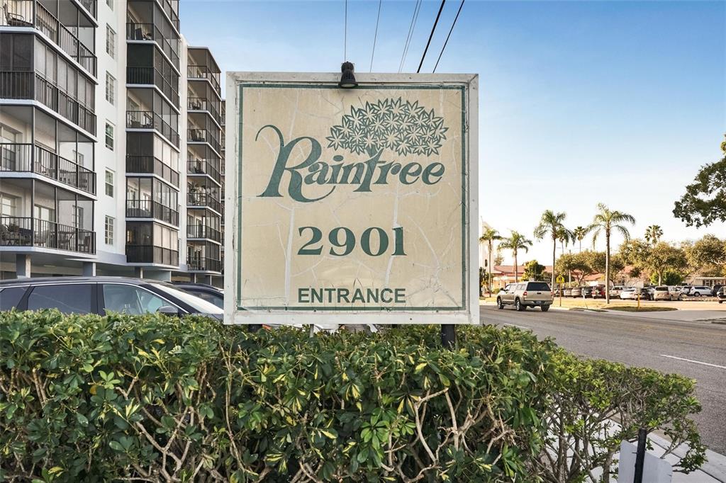 A sign for Raintree 2901 stands in front of a multi-story apartment building and street — 2901 26TH STREET W UNIT 606, BRADENTON, FL