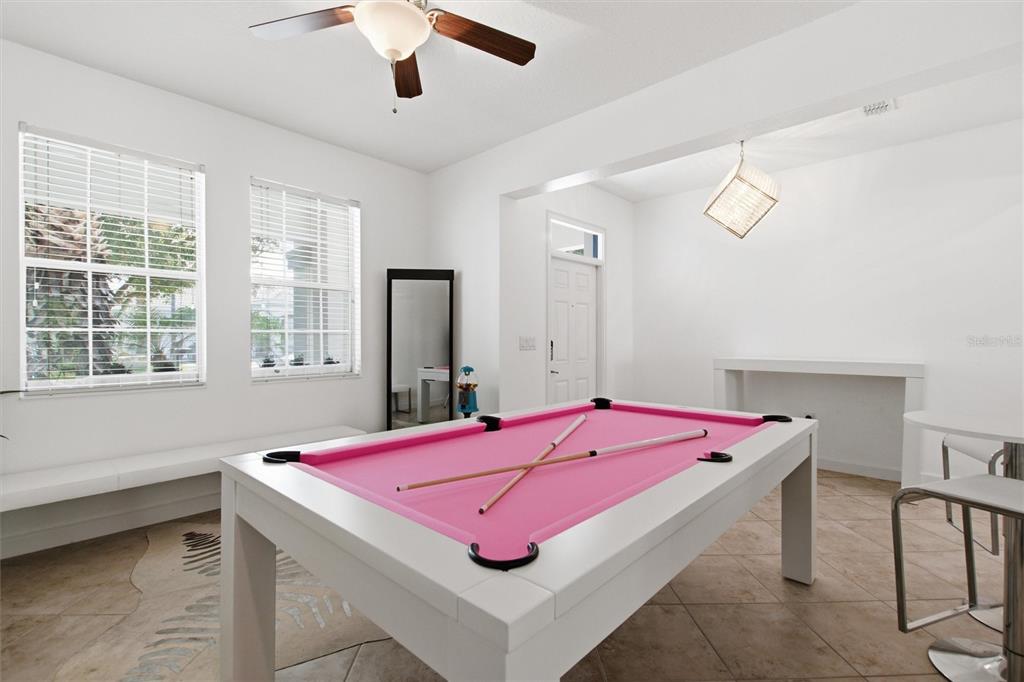 A room with a pink pool table, white walls, tile flooring, and a ceiling fan — 1407 PRO SHOP CT, DAVENPORT, FL