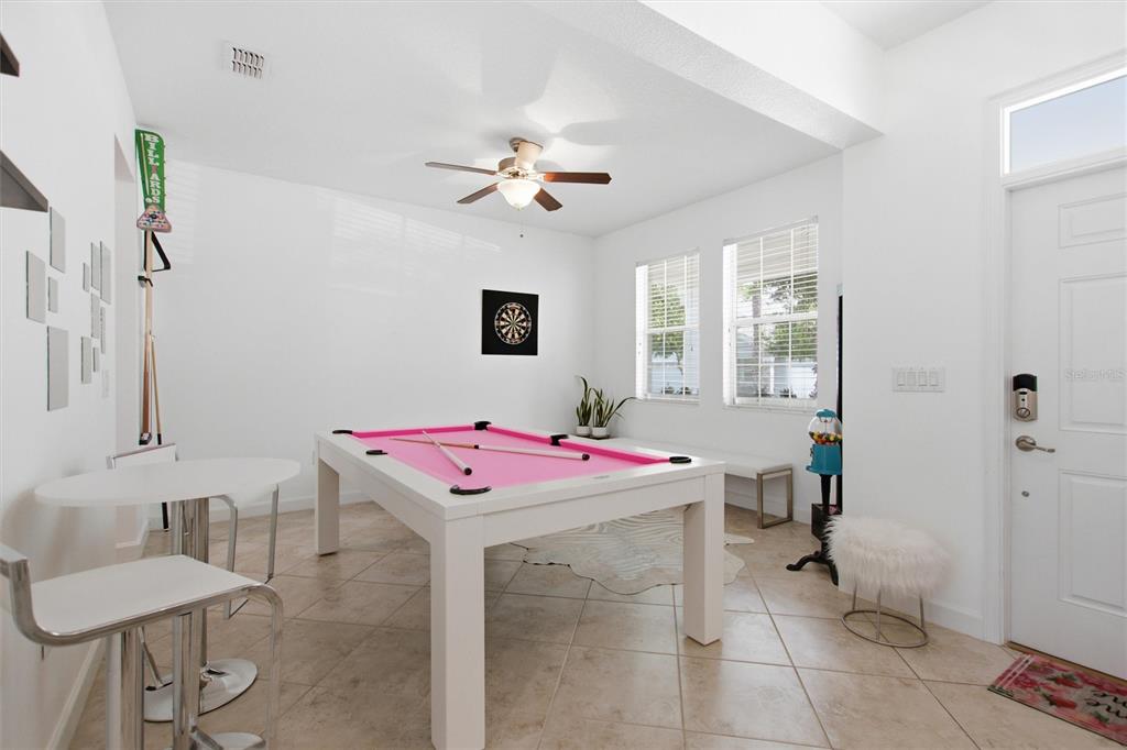 A game room features a pool table with pink felt, tile flooring, and a ceiling fan — 1407 PRO SHOP CT, DAVENPORT, FL