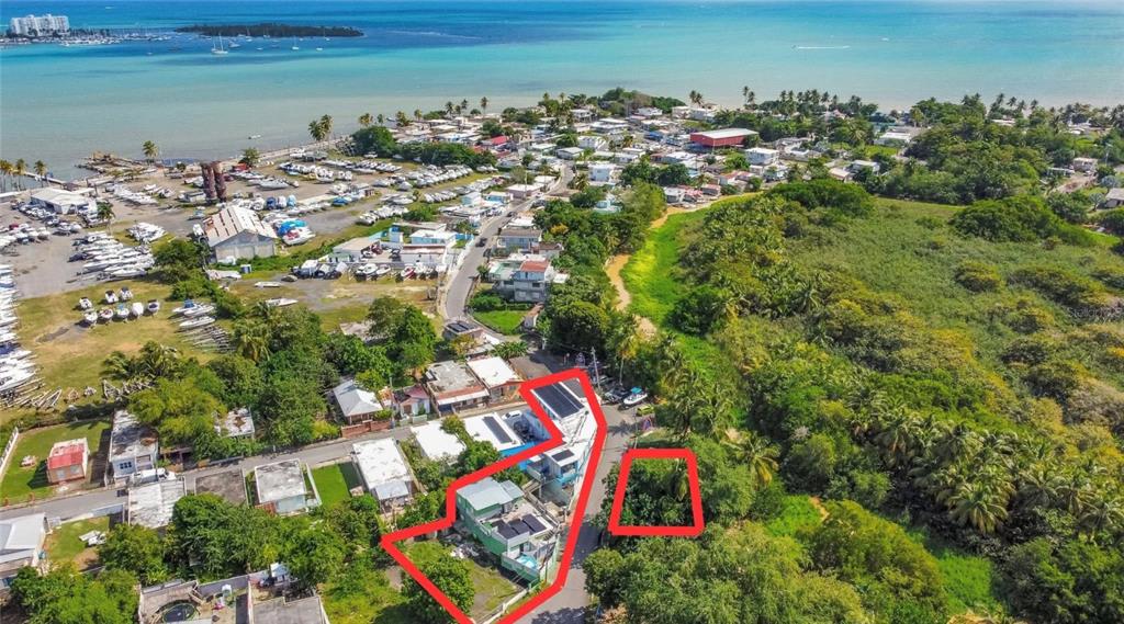 An aerial view shows a coastal neighborhood with two highlighted properties surrounded by trees and water — 0 TABLAZO UNIT 536, FAJARDO, PR