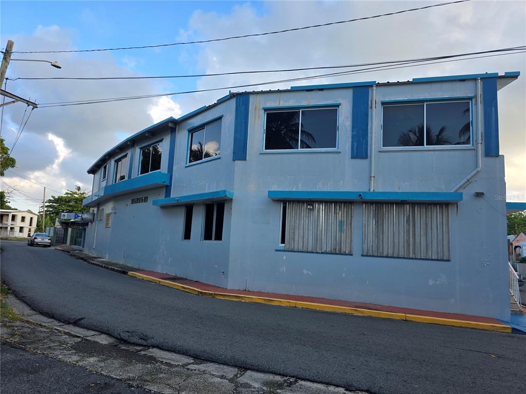 A two-story light blue commercial building sits on a corner lot along a paved street — 0 TABLAZO UNIT 536, FAJARDO, PR