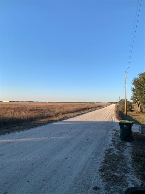 A dirt road runs alongside a large, dry grassy field under a clear blue sky — 49 FENNY BOSK TRAIL, VENUS, FL
