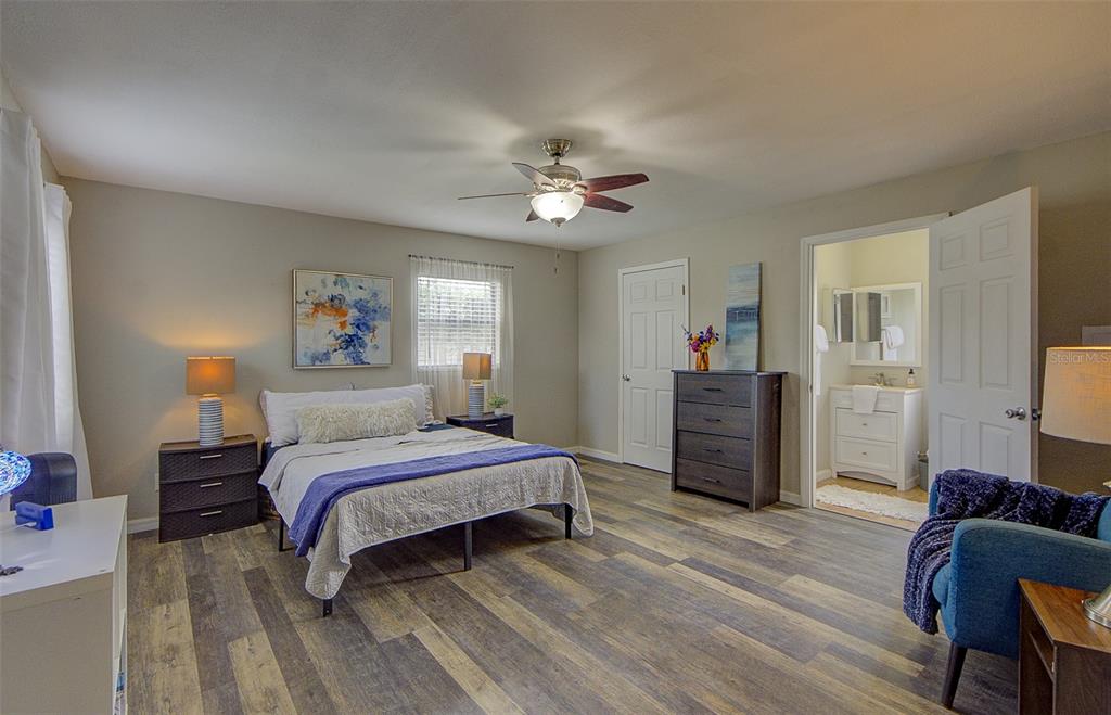 A kitchen features gray cabinets, a white quartz island with bar stools, and stainless appliances — 13222 PINE CREEK CIRCLE, RIVERVIEW, FL