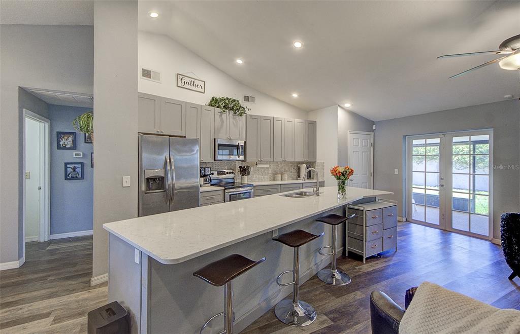 A dining room features a wooden table, white chairs, a ceiling fan, and wall art — 13222 PINE CREEK CIRCLE, RIVERVIEW, FL