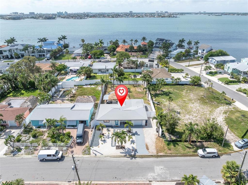 An aerial view shows a single-story house with a white roof near the water — 855 BOCA CIEGA ISLE DRIVE, ST PETE BEACH, FL