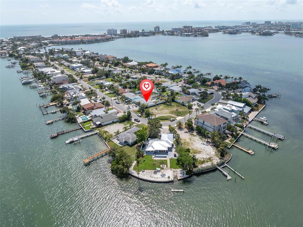 This aerial view shows a residential waterfront property on a peninsula with private boat docks — 855 BOCA CIEGA ISLE DRIVE, ST PETE BEACH, FL